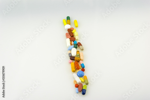 Many colored tablets and capsules isolated on white background.