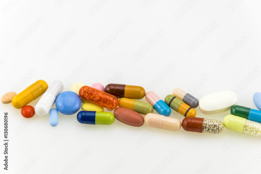 Many colored tablets and capsules isolated on white background. Many colored tablets and capsules isolated on white background.