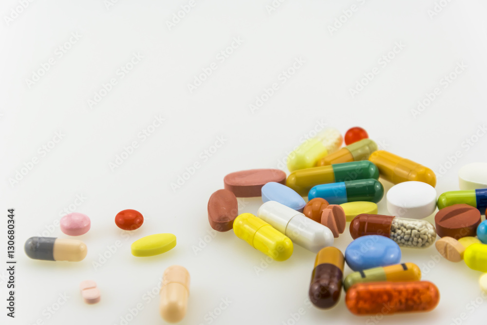 Many colored tablets and capsules isolated on white background. Many colored tablets and capsules isolated on white background.