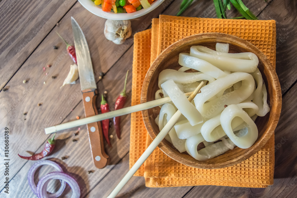 Fresh squid rings and vegetables on a wooden table. top view. Close-up