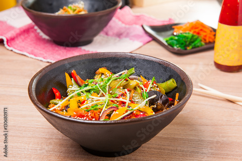 Traditional chinese wok dish vegetables in a sweet - sour sauce garnished with soybean sprouts in a round plate