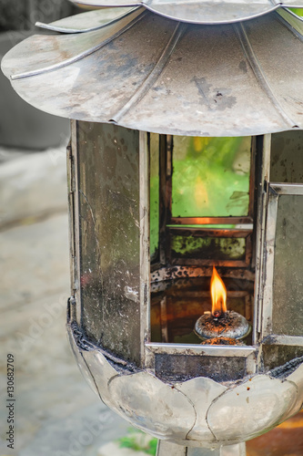 Close-up view of vintage kerosene oil lantern lamp burning with a soft glow light. Soft focus