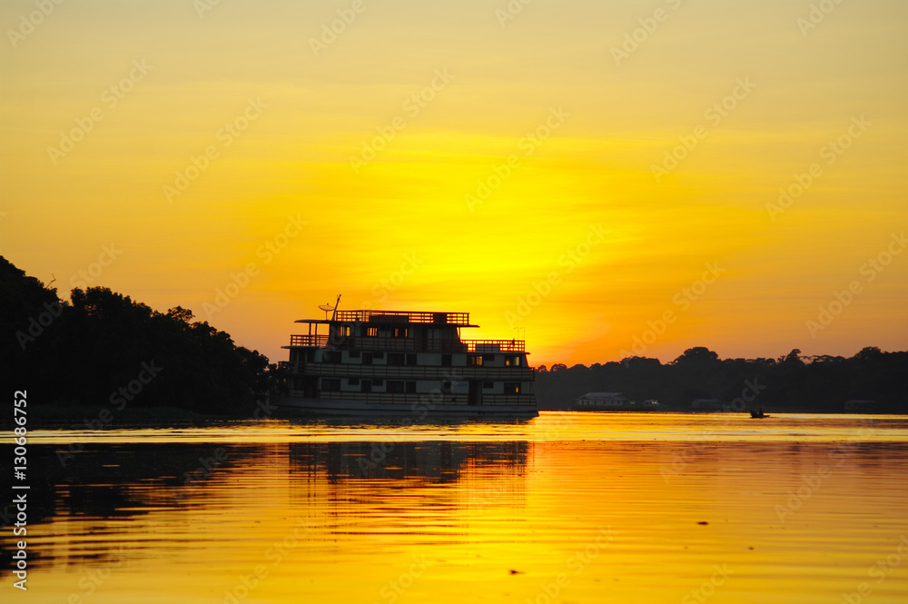 Cruise boat on the Amazon river at sunset.