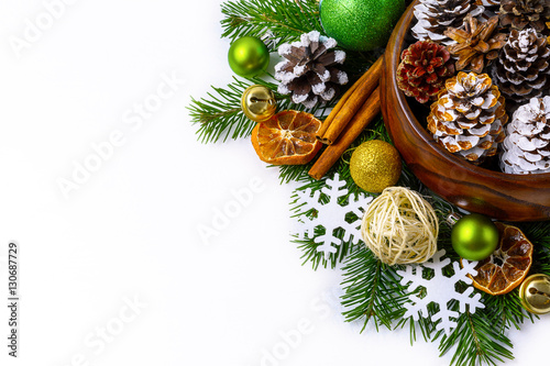 Christmas decorated pine cones in wooden bowl with fir branches