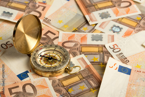 A compass that shows the way. Pile of 50 euro notes - business background. 50 Euro banknotes. Fifty euro money seamless background. Closeup.