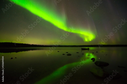 Aurora Borealis and Starry Sky - Multi-colored aurora borealis bright up the starry night sky above a quiet lake.