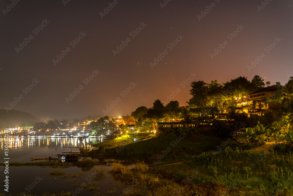 Landscape midnight view of famous Wooded bridge and city in Sangkhlaburi District, Kanchanaburi, Thailand.