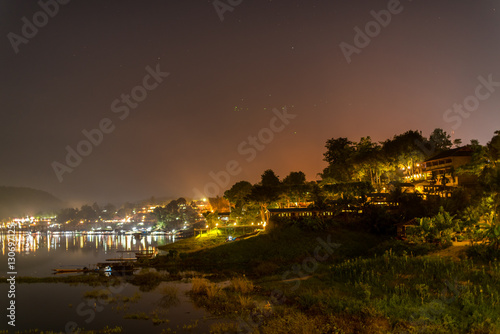 Landscape midnight view of famous Wooded bridge and city in Sangkhlaburi District, Kanchanaburi, Thailand.