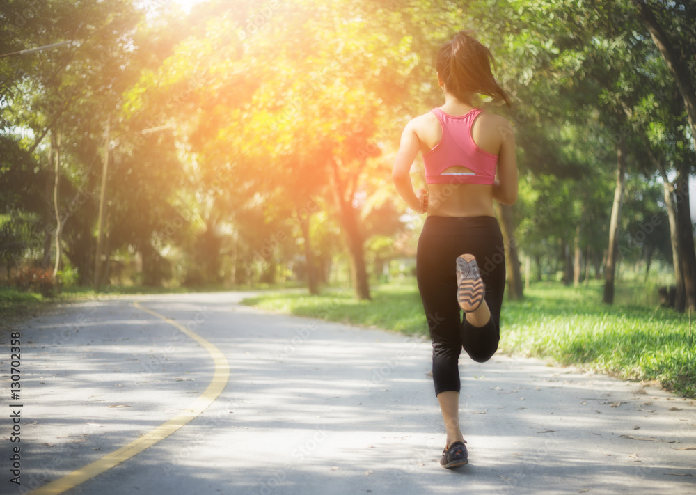 young fitness woman running on the road