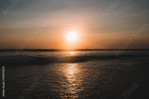 Sunset on the beach of Indian ocean with surfers, Indonesia, Bali © ArinaEmelyanova