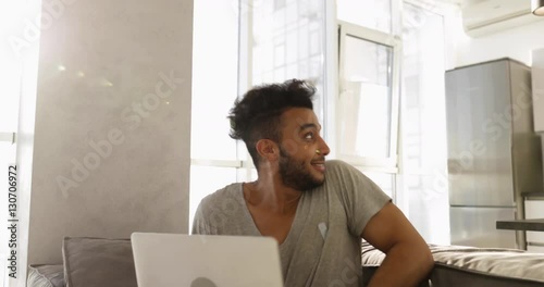 Happy Young Mixed Race Couple Home Interior, Hispanic Man Using Laptop Computer, Asian Woman Cooking Breakfast Slow Motion