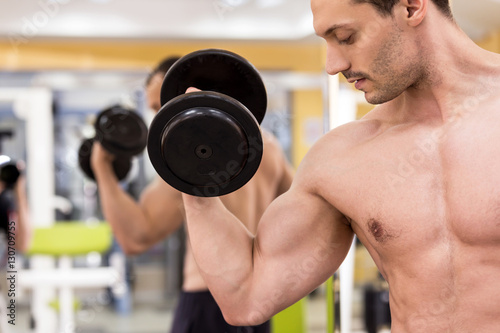 bodybuilder man with a dumbbell in fitness club
