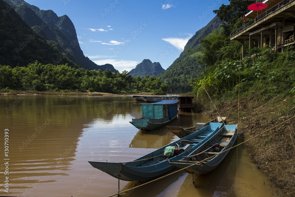 Obraz premium Long boats on the river with mountains