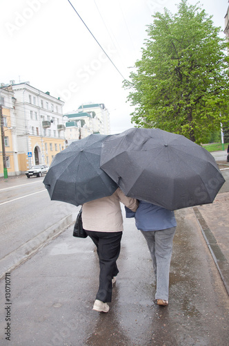 Two women go under umbrellas in heavy rain
