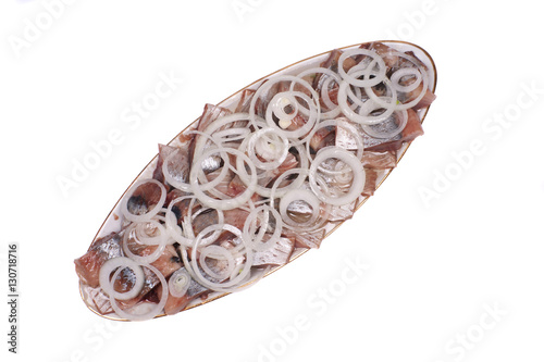 oval dish with herring and onion on a white background