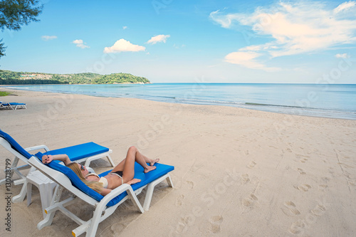 Tropical vacation. Young beautiful woman relaxing on the beach.