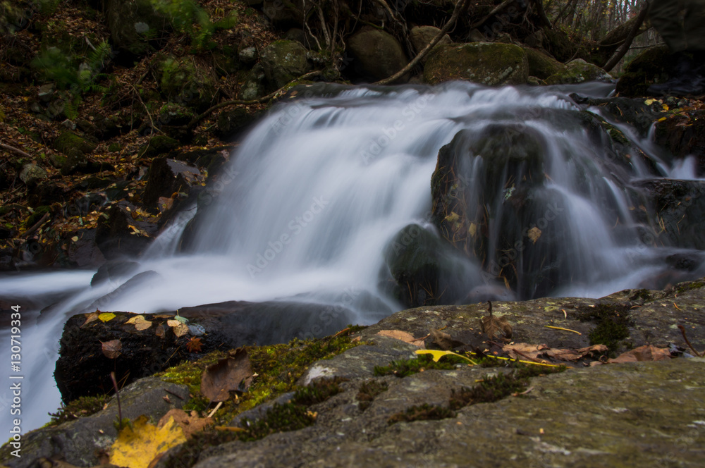 Fototapeta premium Wide waterfall in the autumn dark forest