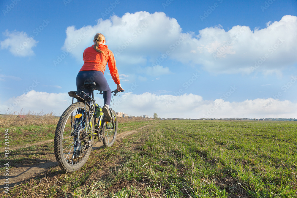Bike riding -  woman riding on a bicycle in nature offroad.  Sport and fitness concept.