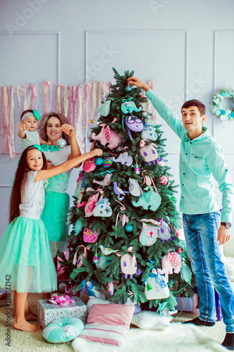 The happinest family decorating a Christmas tree