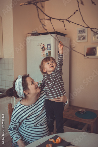 happy mother and son at kitchen  hugging, chatting. Real interio photo