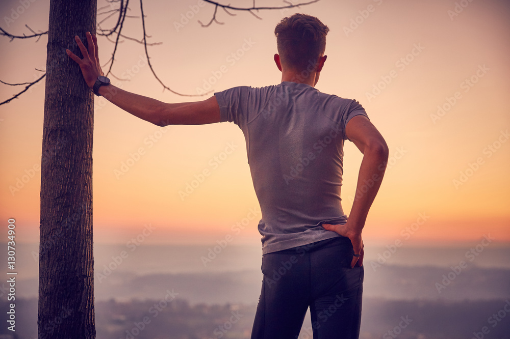 Fototapeta premium Ragazzo in vetta, tramonto in montagna