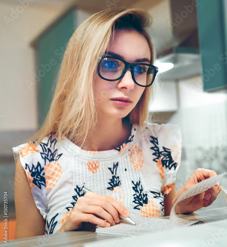 Obraz na płótnie Girl sitting at home writing in a paper notebook w salonie
