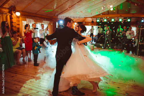 beautiful and young bride and groom dancing their first dance photo