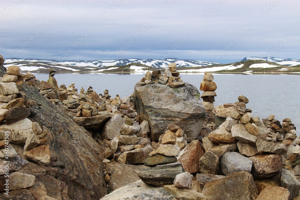 Pebble towers on the lakeside. In the Hardangervidda national park, or Hardanger mountains plateau, in Norway, Europe. Height above sea level approx. 1100 meters.