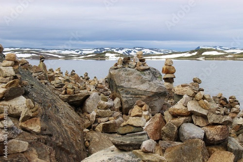Pebble towers on the lakeside. In the Hardangervidda national park, or Hardanger mountains plateau, in Norway, Europe. Height above sea level approx. 1100 meters. photo