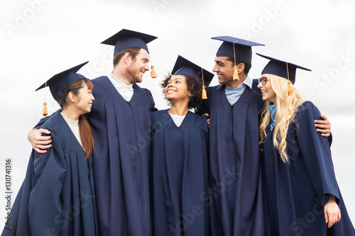 happy students or bachelors in mortar boards