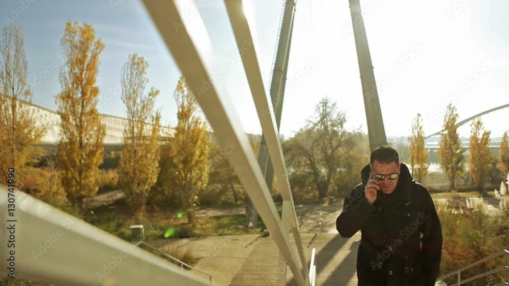 Estilo de vida y la comunicación en la ciudad. Parque moderno y Hombre hablando por teléfono inteligente. Puesta de sol paisaje urbano