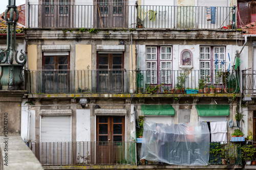 Front view on old rusting balconies in poor house of flats in Po photo