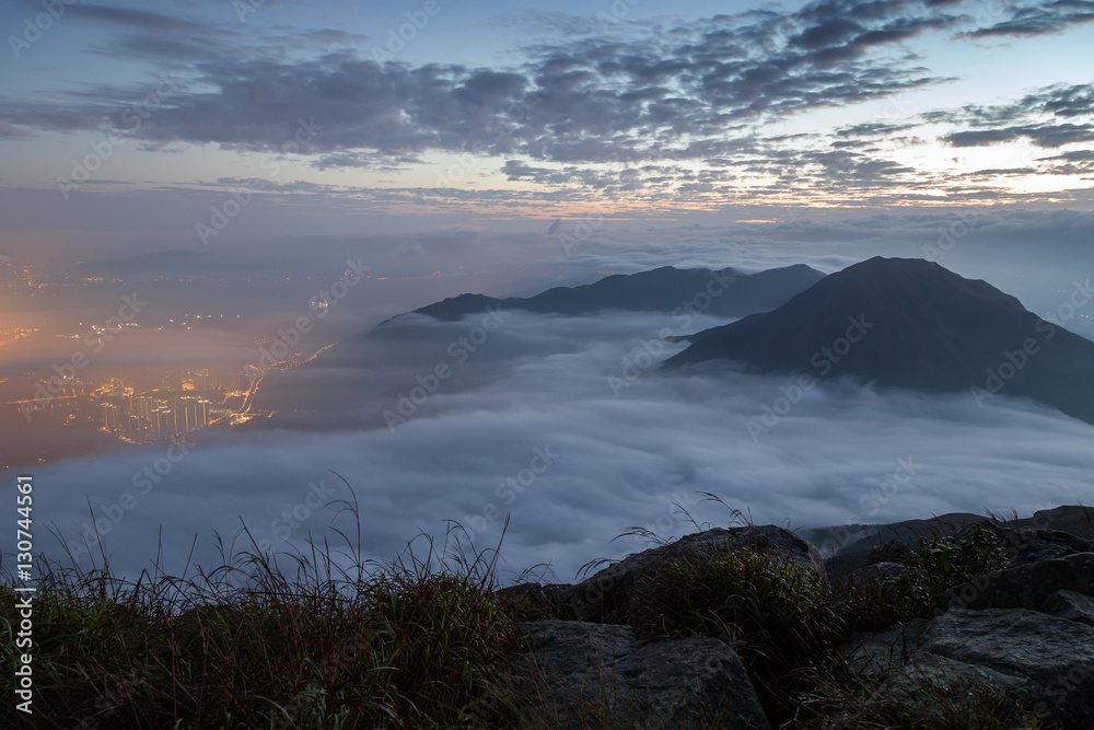 Clouds rolling over mountain peaks on Lantau Island, viewed from the Lantau Peak (the 2nd highest peak in Hong Kong, China) at dawn.