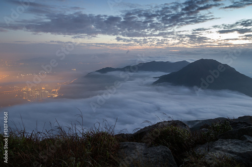 Clouds rolling over mountain peaks on Lantau Island, viewed from the Lantau Peak (the 2nd highest peak in Hong Kong, China) at dawn.
