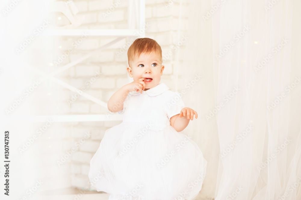 beautiful baby girl in a white dress in the interior with Christ beautiful baby girl in a white dress in the interior with Christ