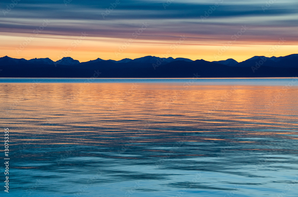 Fototapeta premium Beautiful red sunset over the lake with mountain