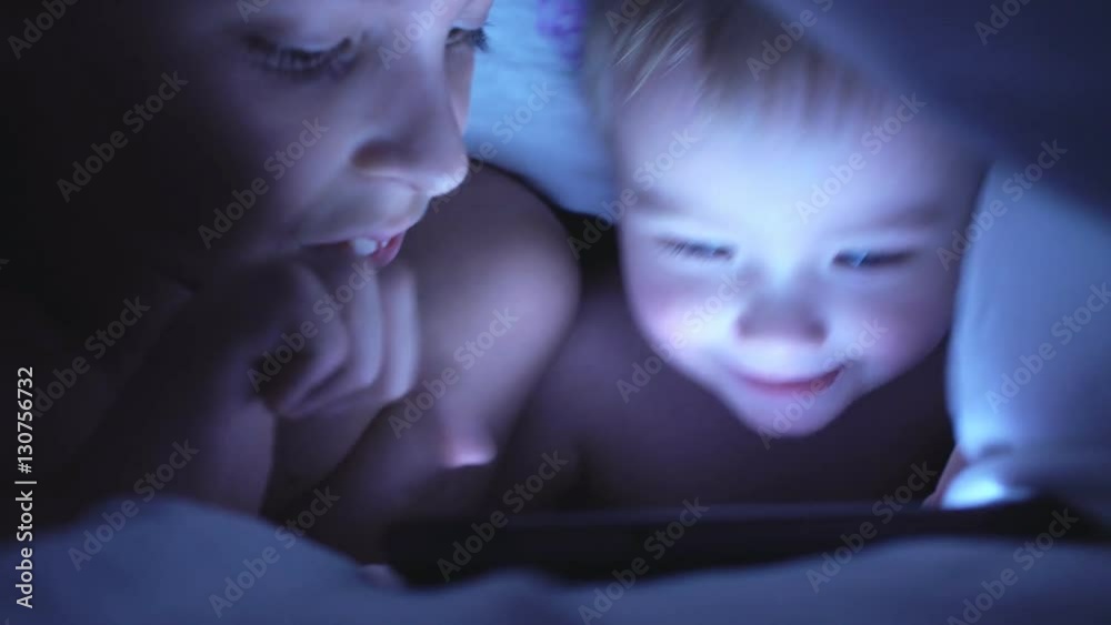 Brothers With Tablet In A Dark Room Under Blanket. 4K Brothers With Tablet In A Dark Room Under Blanket. 4K
