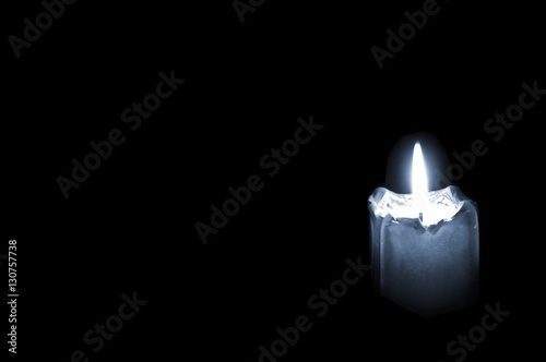 Εκτύπωση καμβά Glowing mourning candle on black background with empty space for text