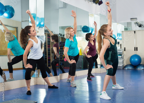 Fototapeta Naklejka Na Ścianę i Meble -  Positive females working out at aerobic class in modern gym