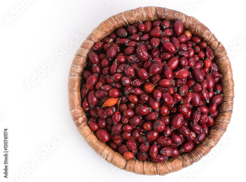 Dried rose hips in wicker basket isolated on white background
