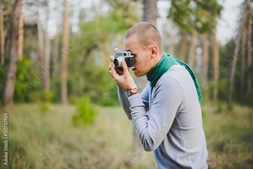 man with retro vintage camera in the forest