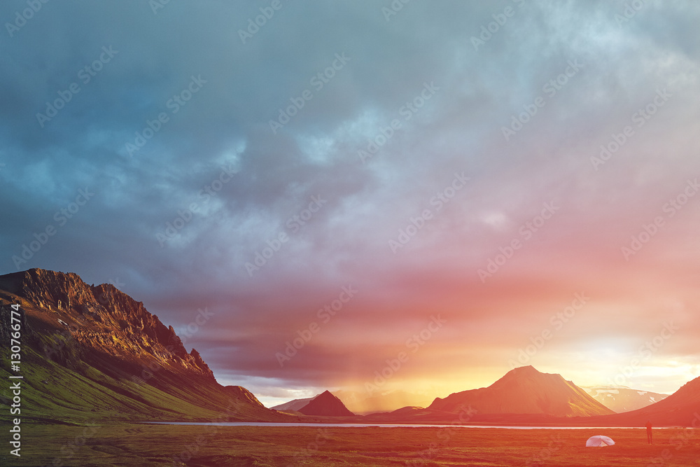 Fototapeta premium Travel to Iceland. Beautiful Icelandic landscape with mountains, sky and clouds. Trekking in national park Landmannalaugar. Rainy Evening in Camping near Alftavatn lake.