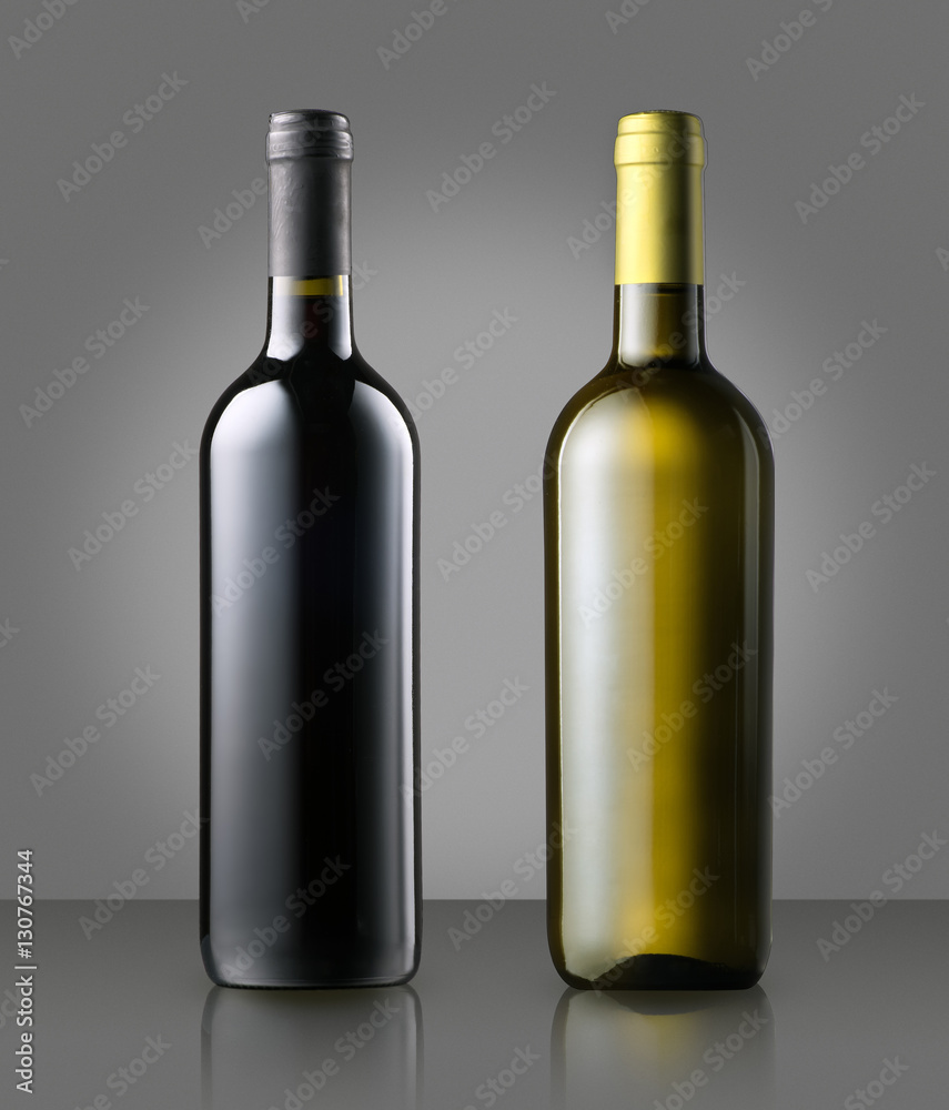 Unlabelled red and white wine bottles on gray Unlabelled red and white wine bottles on gray