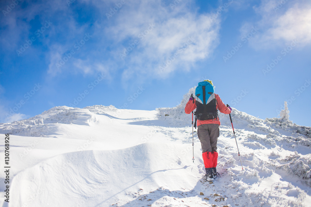 Girl with backpack walking on snow in the mountains. Girl with backpack walking on snow in the mountains.
