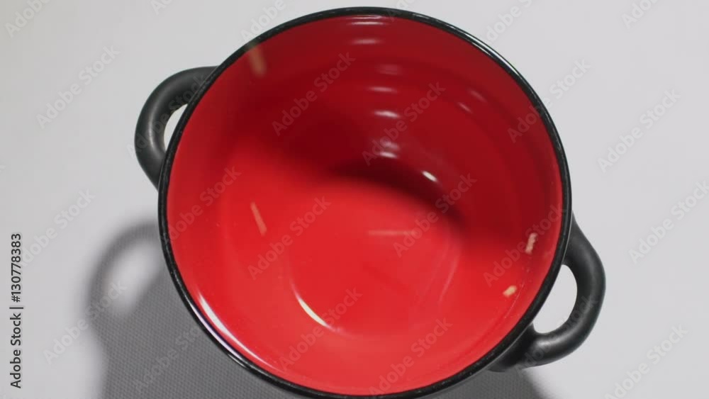 Couscous pours cereal into a red bowl in slowmotion Couscous pours cereal into a red bowl in slowmotion