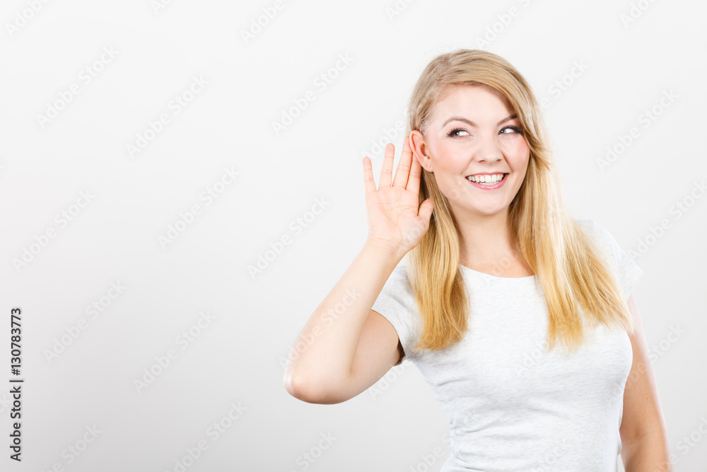Woman putting hand ear to hear better Woman putting hand ear to hear better