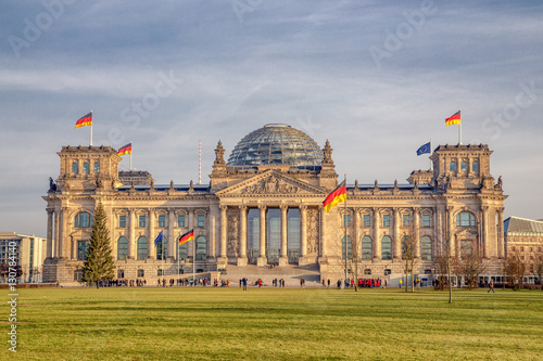 Panoramic view of famous Reichstag building, seat of the German Parliament (Deutscher Bundestag), in beautiful golden evening light at sunset, Berlin Mitte, Germany.