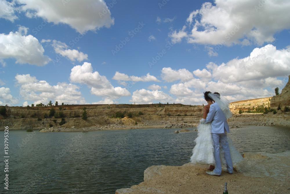 Embracing bride couple looks into the distance Embracing bride couple looks into the distance