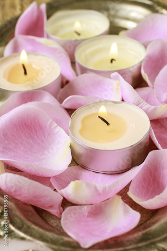 Tiny candles among pink rose petals