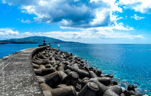 Experiencing tranquility as a sailboat leaves the harbor in Ponta Delgada